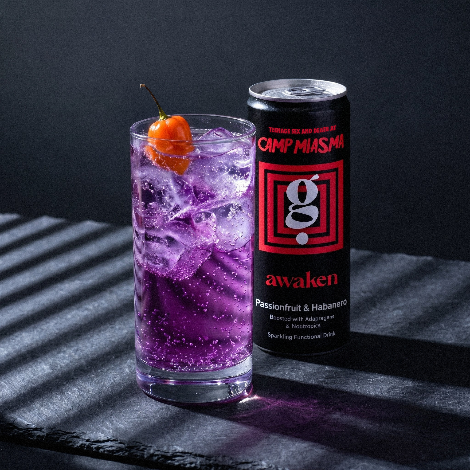 Glass with purple awaken soda and habanero chilli in drink with awaken can behind
